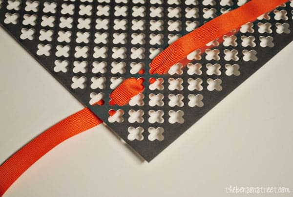 Halloween door sign threading ribbon through metal sign