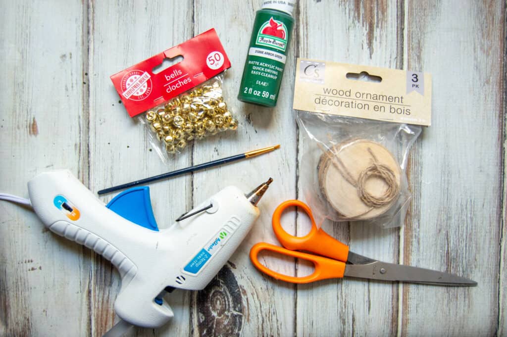 Decorate your tree with rustic charm with this simple DIY wood slice tree ornaments. Dress up the wood rounds with evergreen trees and bells for a festive dollar store craft.