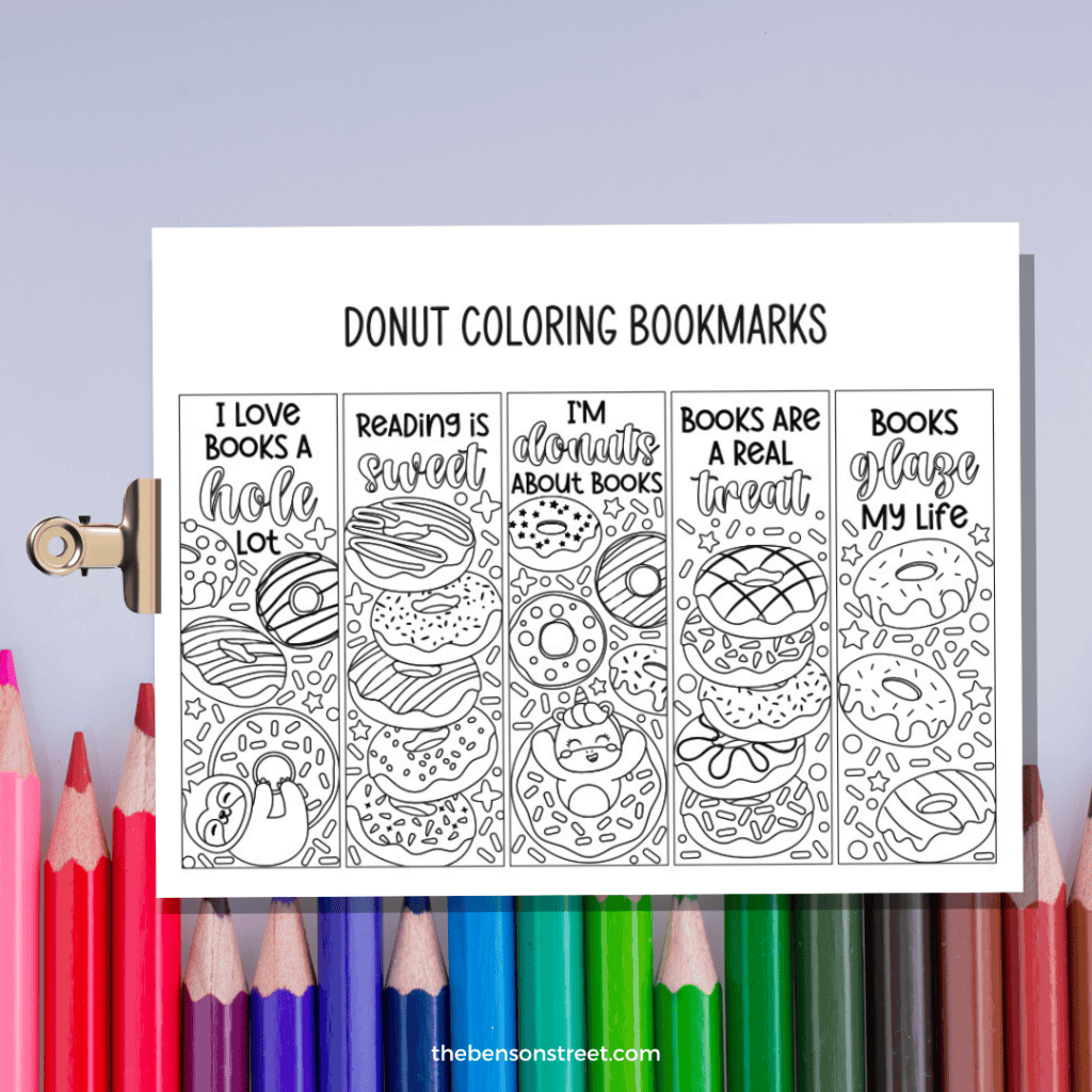 five donut themed coloring bookmarks on a clipboard ready to be colored with colored pencils in the background.