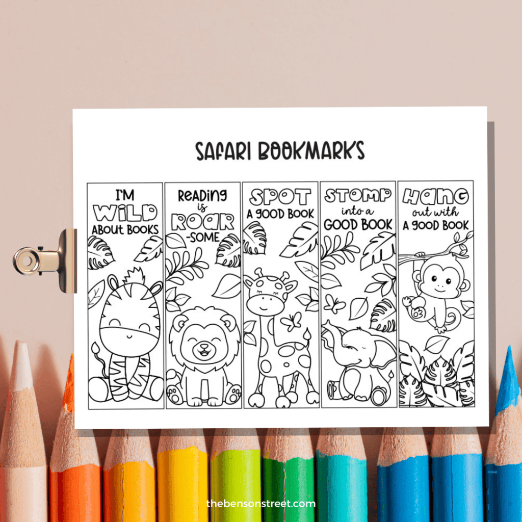 A set of five free printable safari animal coloring bookmarks on a clipboard with colored pencils in the background.