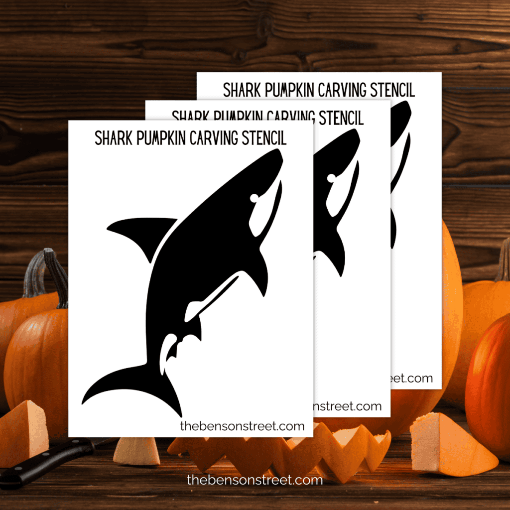 Close-up view of a printable shark pumpkin stencil showing the detailed silhouette of a shark, including a curved tail fin.
