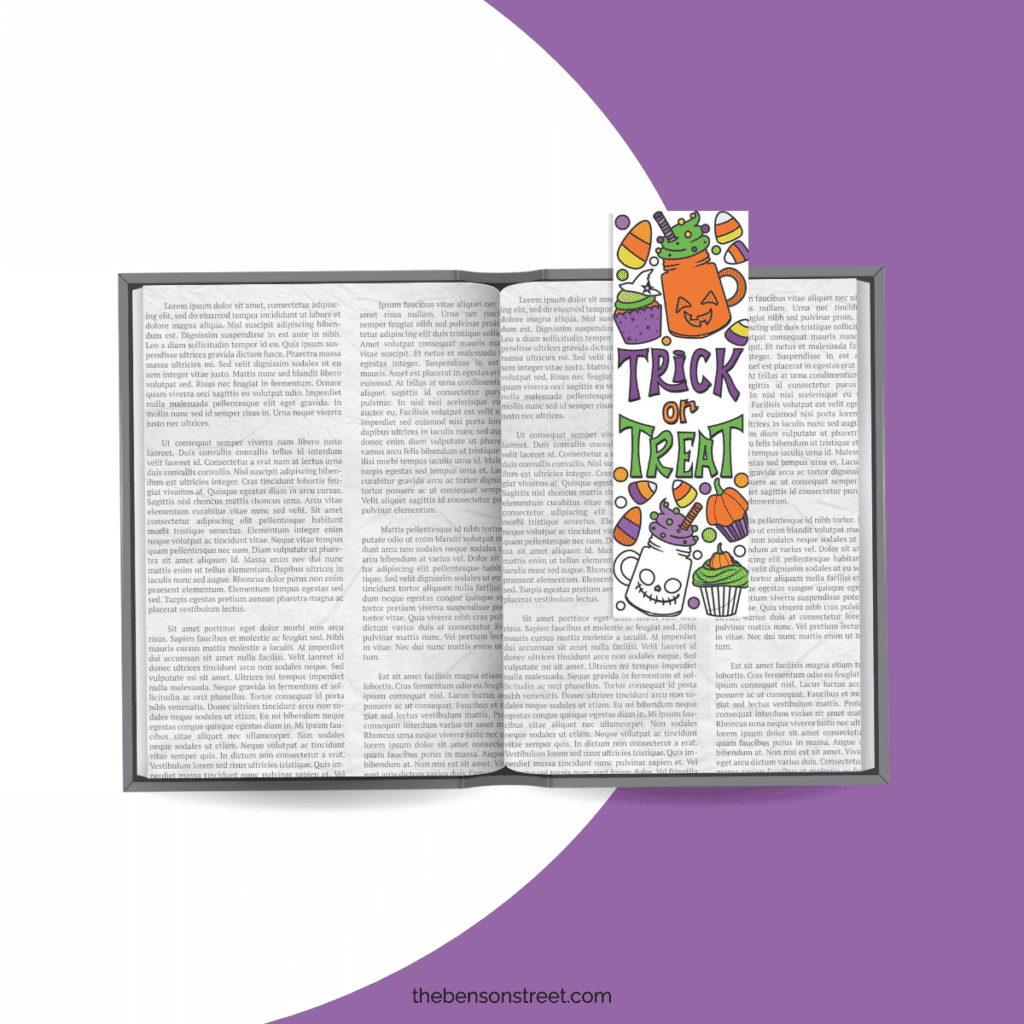 An open book with a colored in Halloween bookmark on the page.