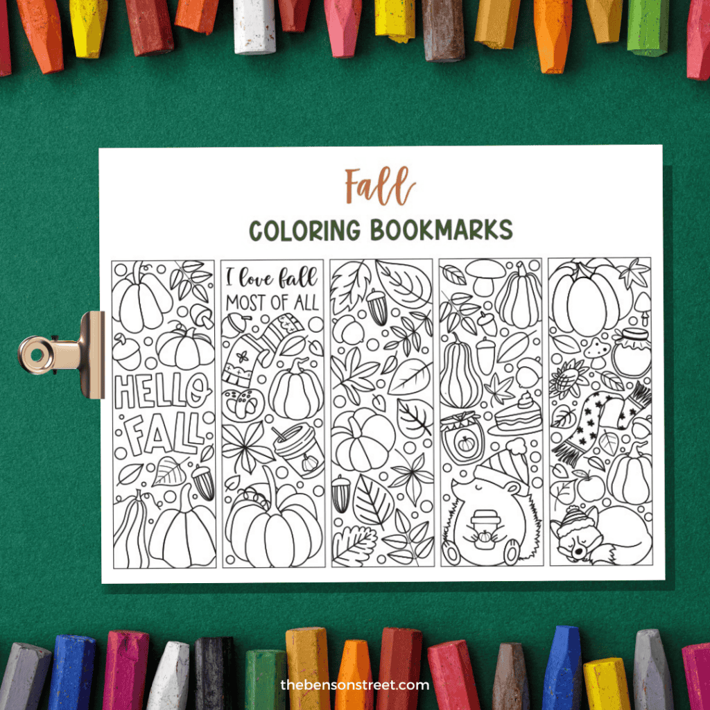 Page of fall coloring bookmarks on a clipboard with a green background with crayons.