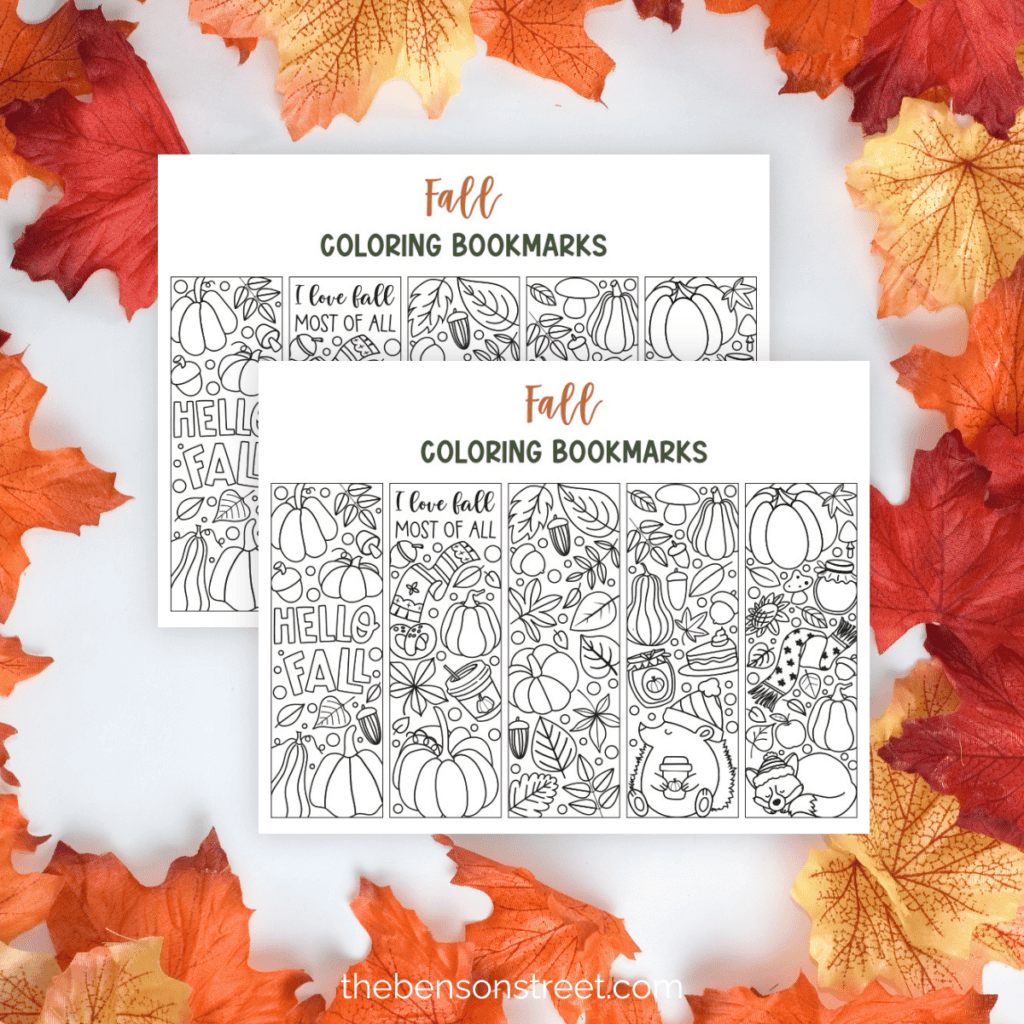 Two sheets of fall coloring bookmarks stacked on top of eachother with leaves in the background.