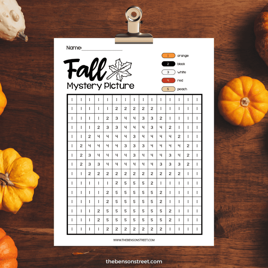 A blank grid ready to be colored in on a clipboard with a fall mystery picture color by number sheet on it.