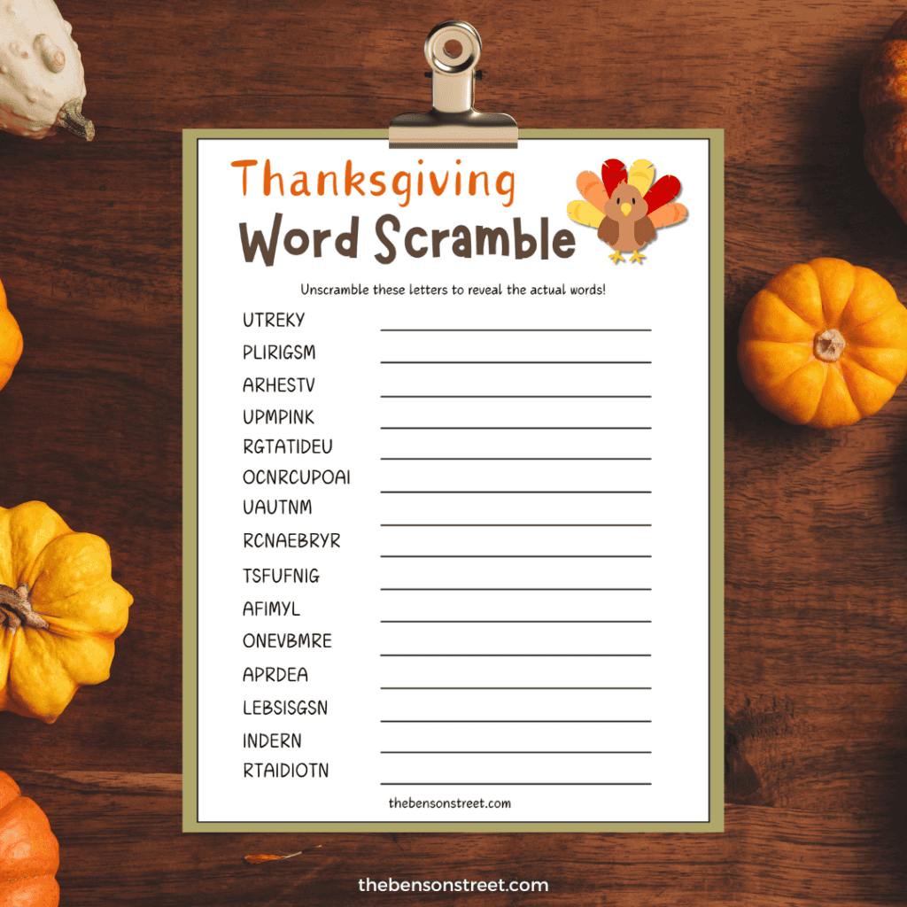 Thanksgiving word scramble printable on a clipboard with a dark wood background with pumpkins.