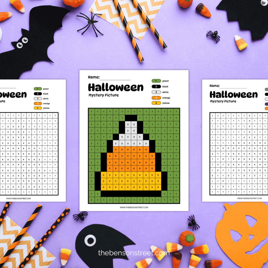 Flat lay of a colored in candy corn halloween mystery picture color by number with two uncolored mystery picture grids on each side.