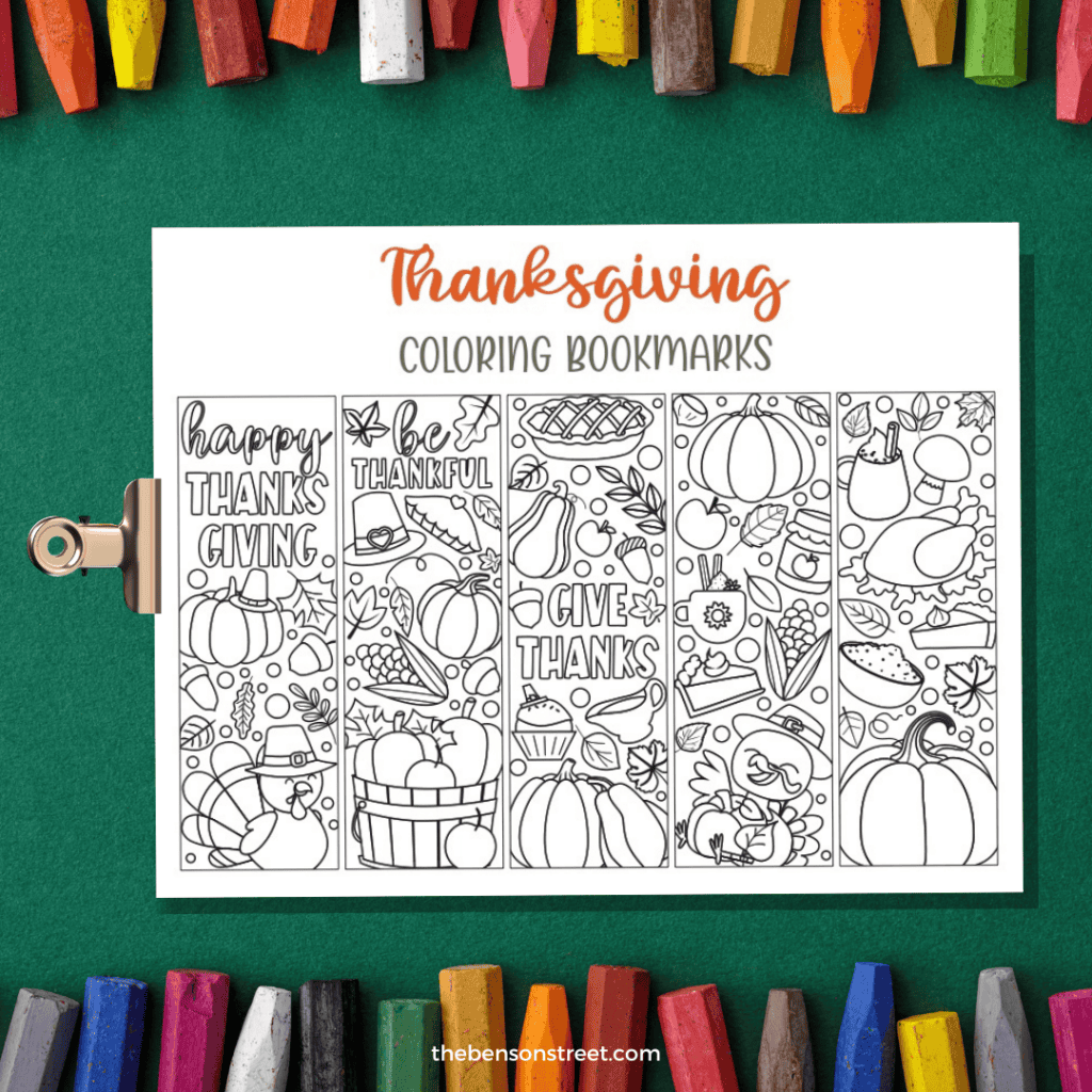 A green background with a crayons with a clipboard with a page of printable thanksgiving bookrmarks to color on the clipboard.