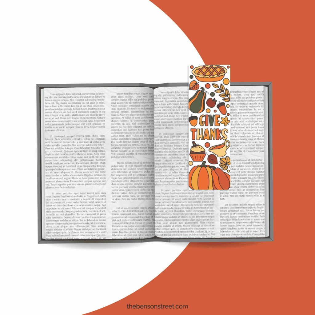 An open book with a free coloring  thanksgiving bookmark that says give thanks and colored in.