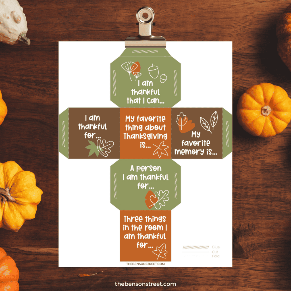 Printed out paper Thankful Dice ready to be assembled on a wood background.