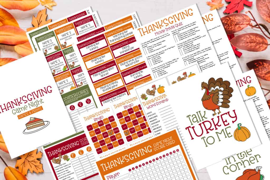 Flat lay of all the free printables included in the free printable Thanksgiving party games for a Thanksgiving game night.