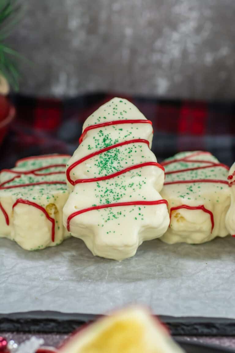 Close up image of a Little Debbie Christmas Tree Cake propped up against other cakes