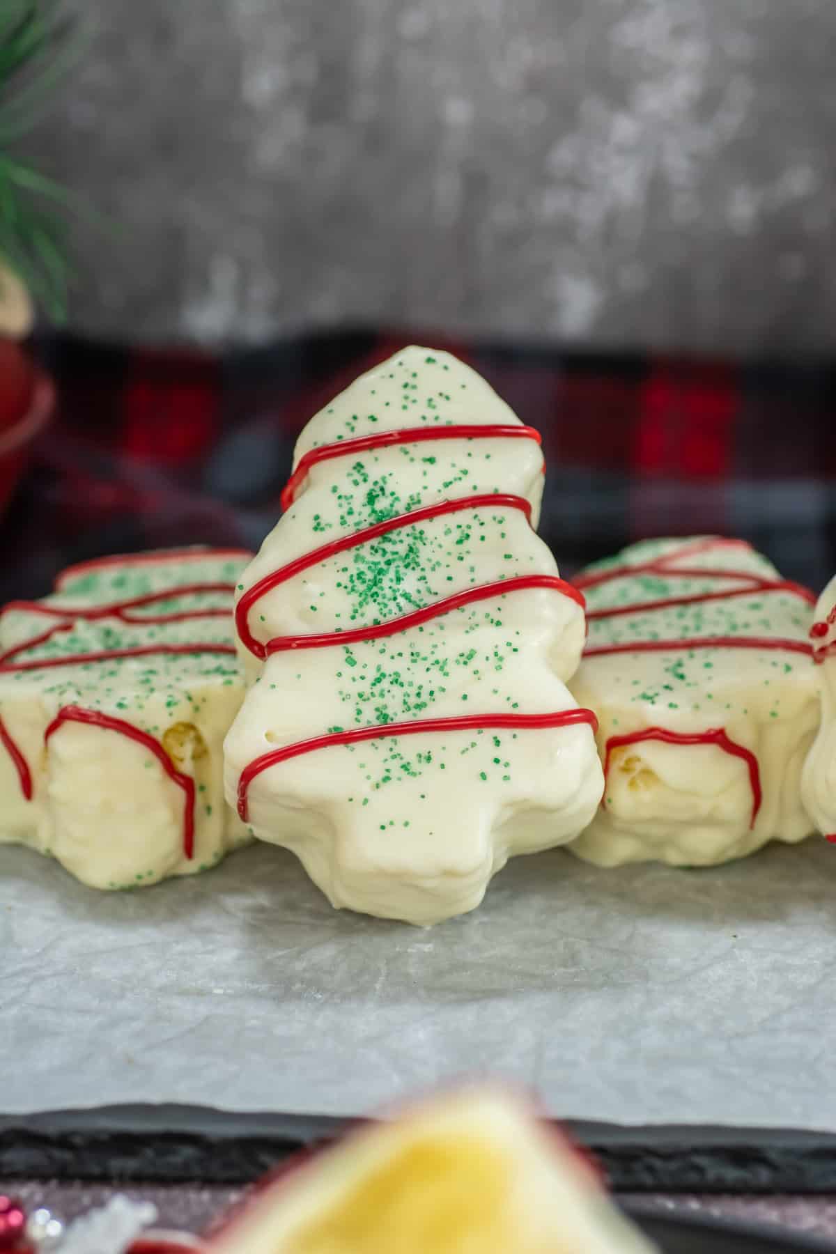 Close up image of a Little Debbie Christmas Tree Cake propped up against other cakes