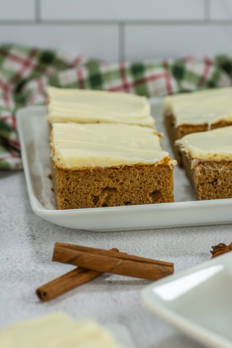 Slices of gingerbread sheet cake with a tea towel in background