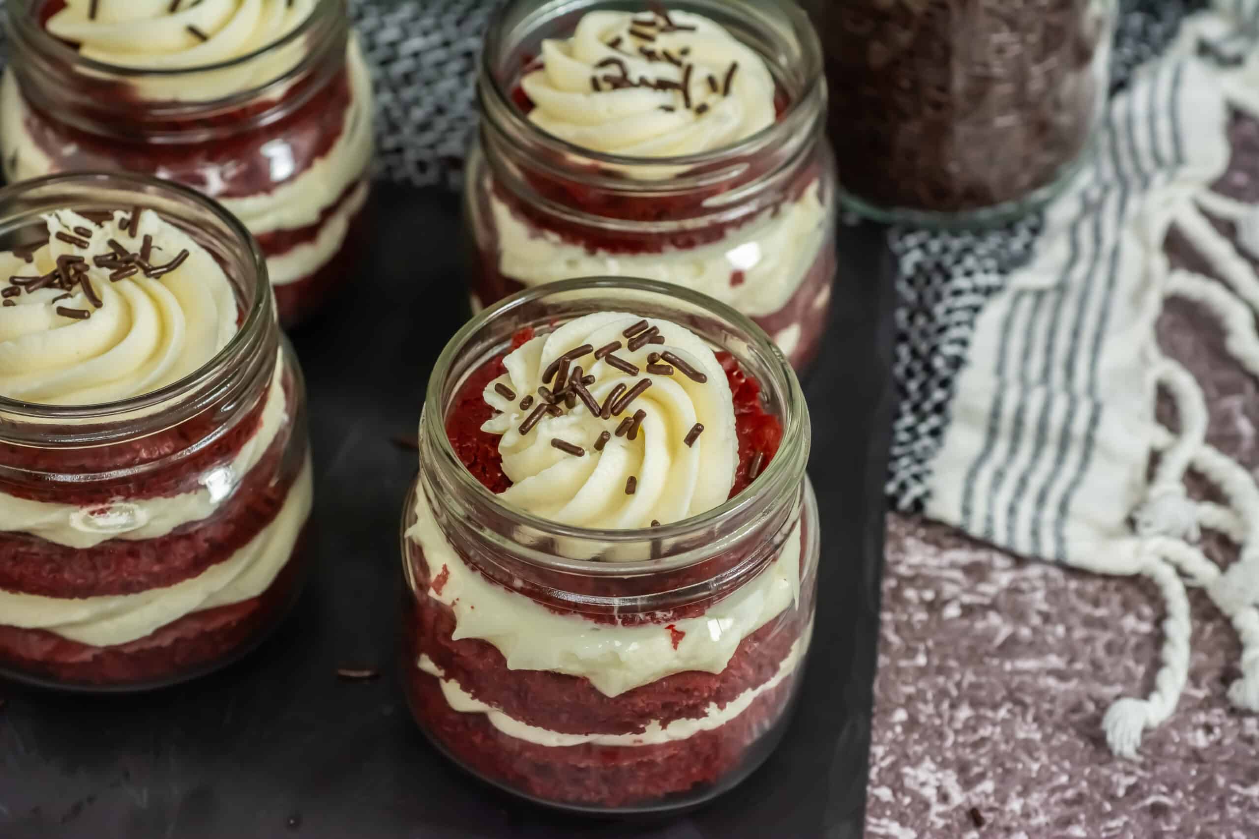 Side View of red velvet jar cakes with chocolate sprinkles on top