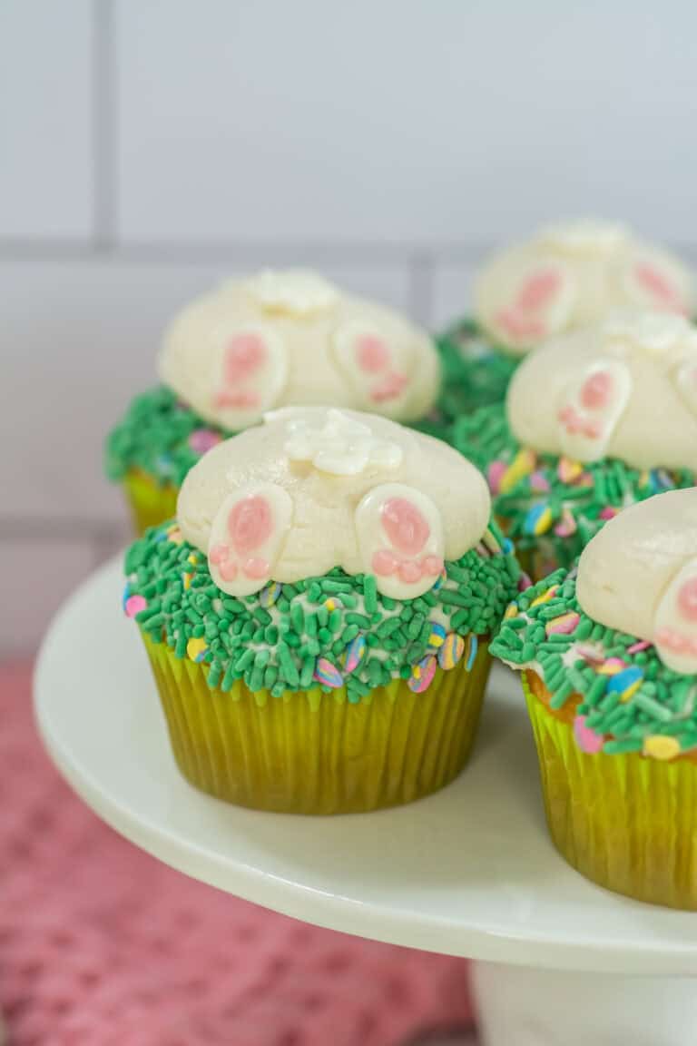 Easter bunny butt cupcakes on a white cake stand decorated and ready to serve