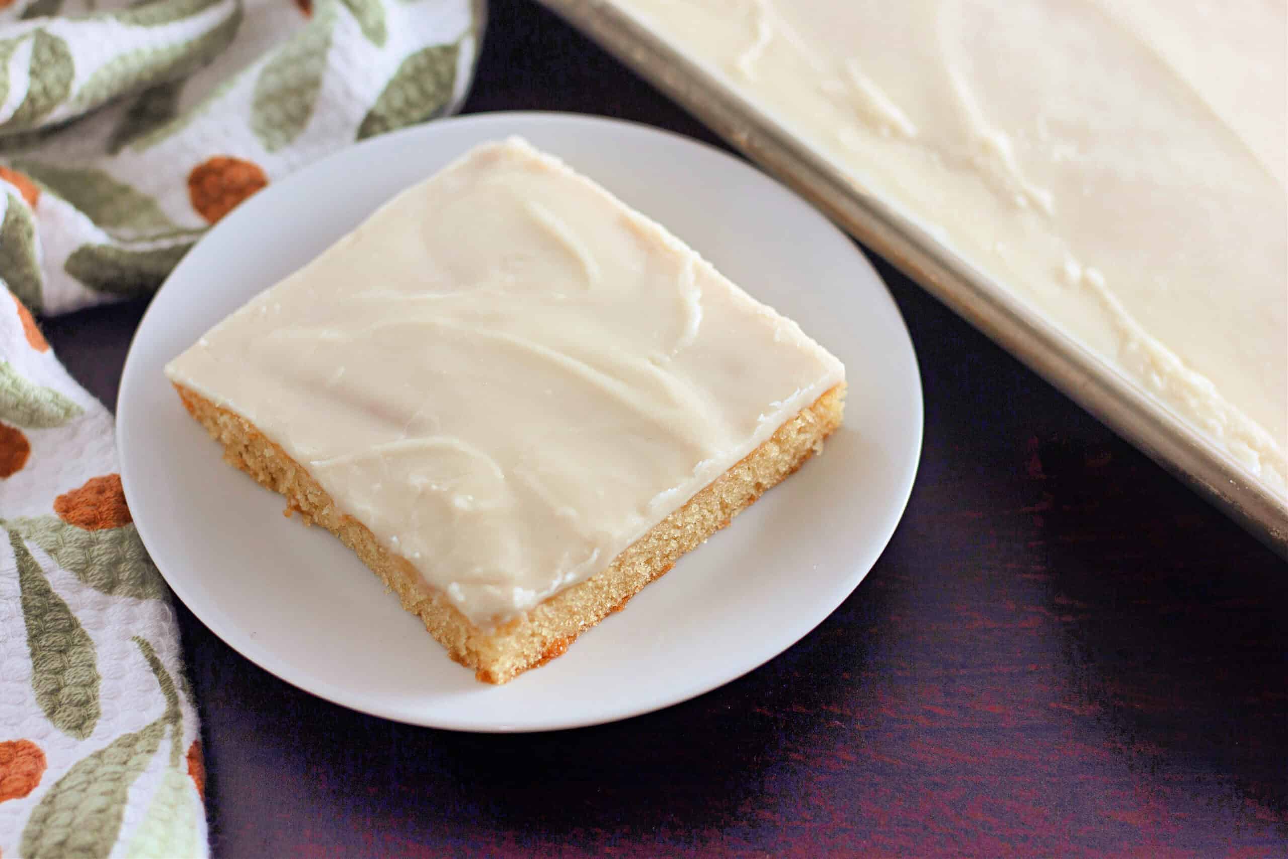 Overhead shot of a slice of white or vanilla texas sheet cake shot from above with pan in shot