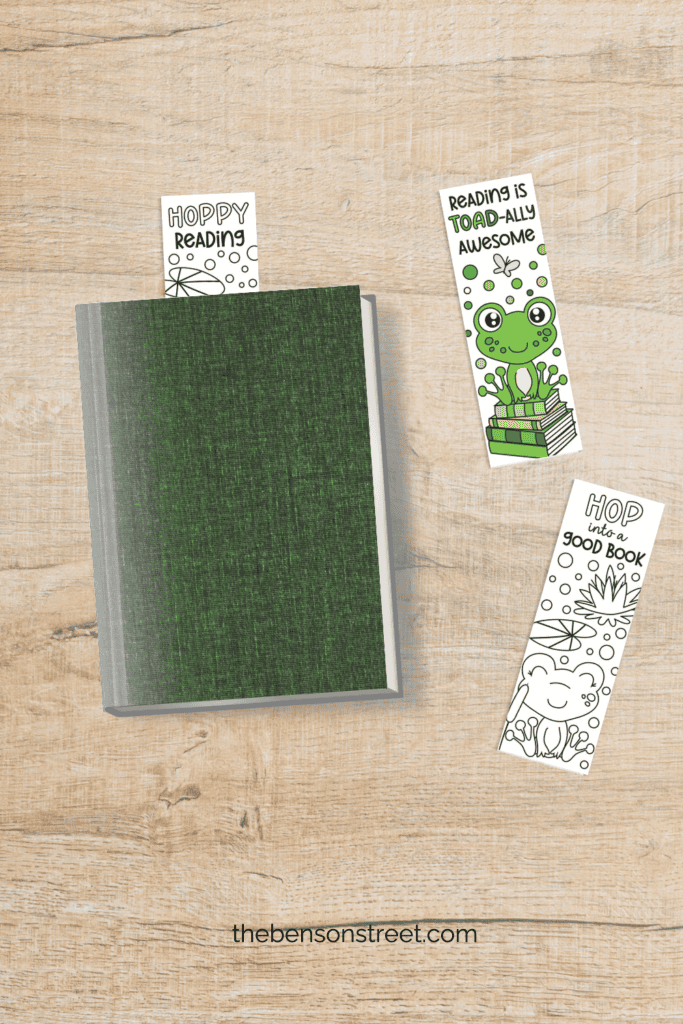 Flat lay shot from above of a book with a bookmarks sticking out of it and two frog coloring bookmarks to the side of it