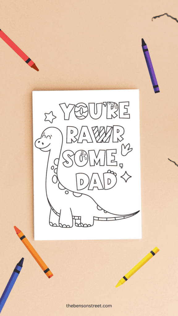 You're rawr some dad dino themed coloring cards with crayons around it shot from above