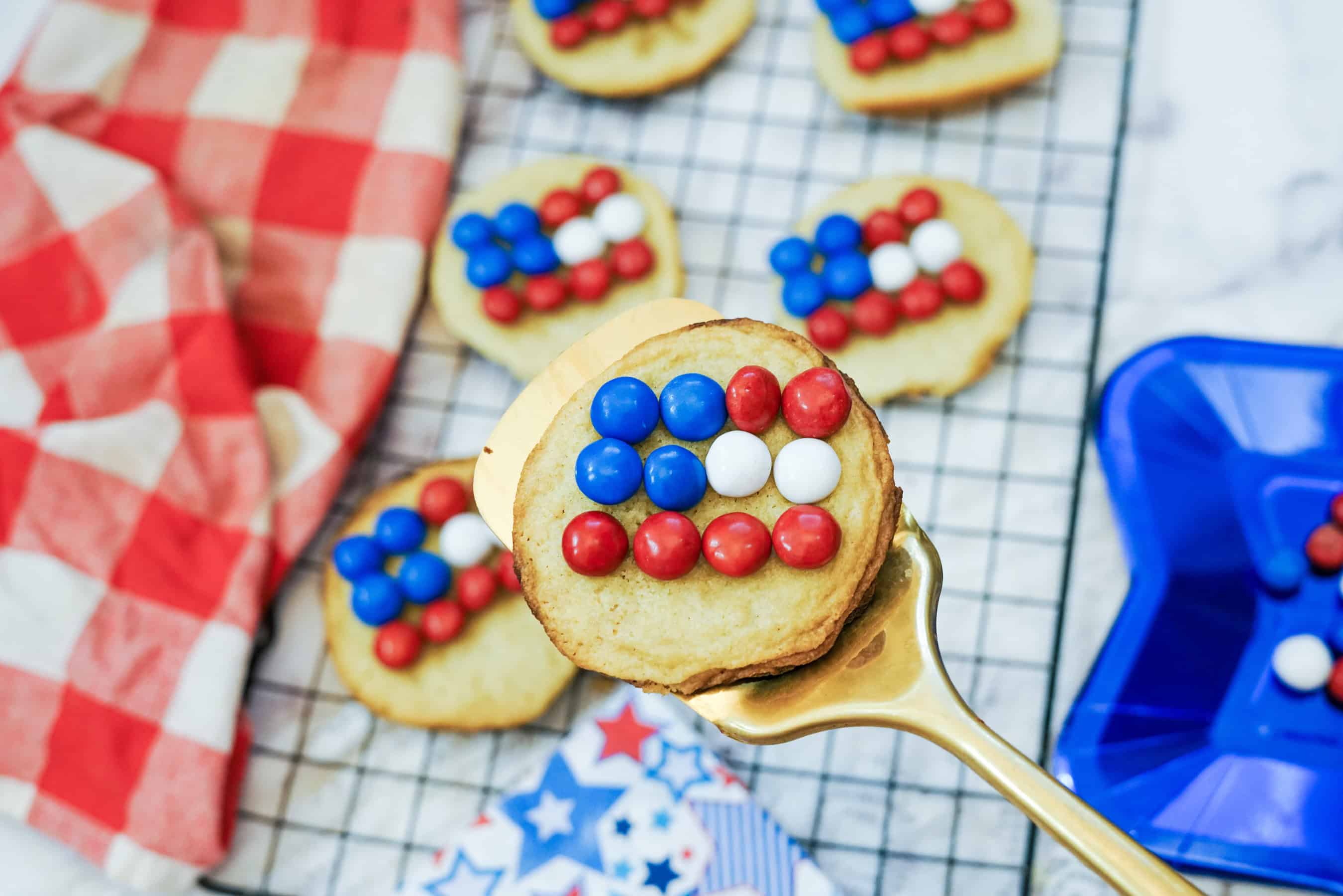 One Sugar Cookie Flag cookie on a spatula with others in the background