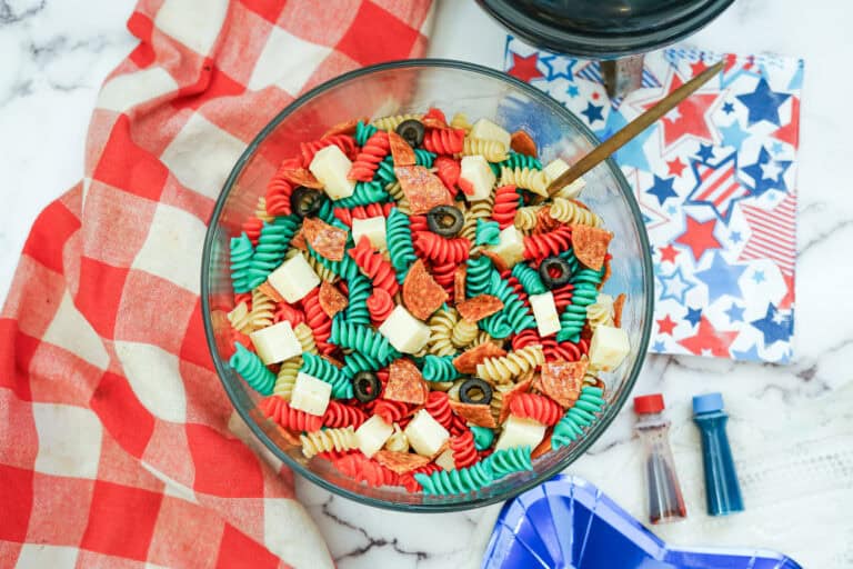 glass bowl with a cold pasta salad in red white and blue