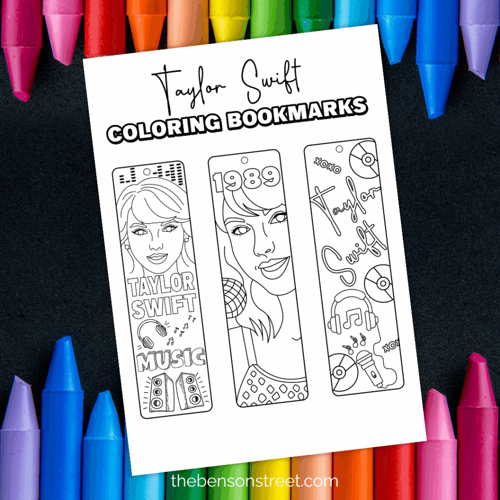 Black background with crayons on a page with a sheet of black and white bookmarks to color