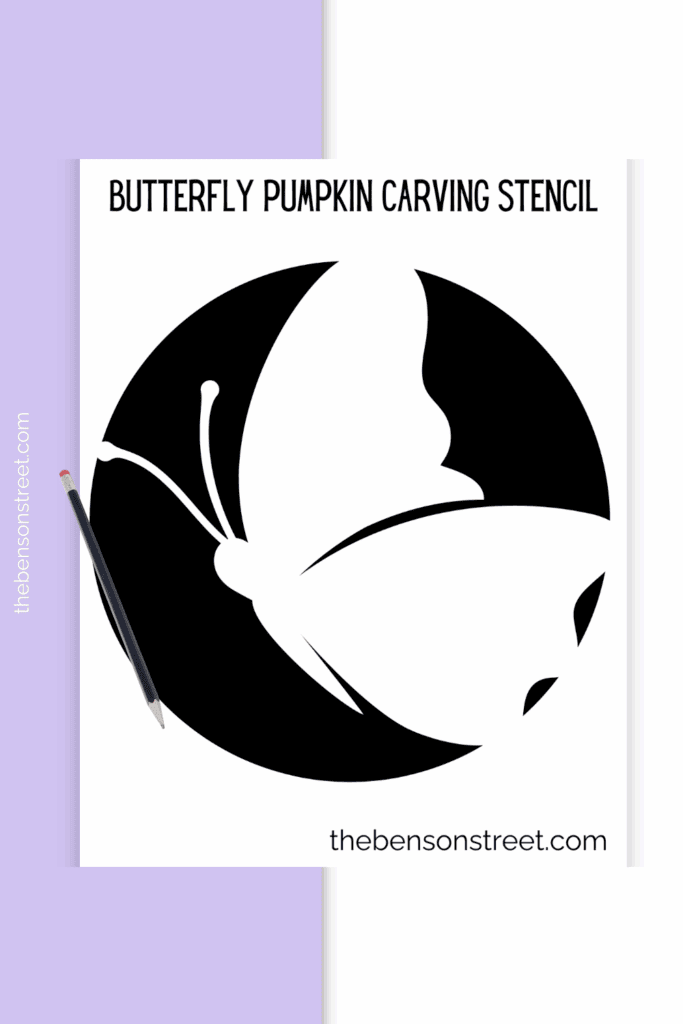 A printed out pumpkin carving stencil with a butterfly outline with a pencil on top