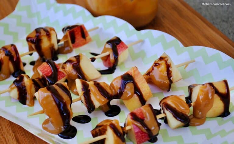 up close shot of apple cubes on skewers with caramel drizzled on top