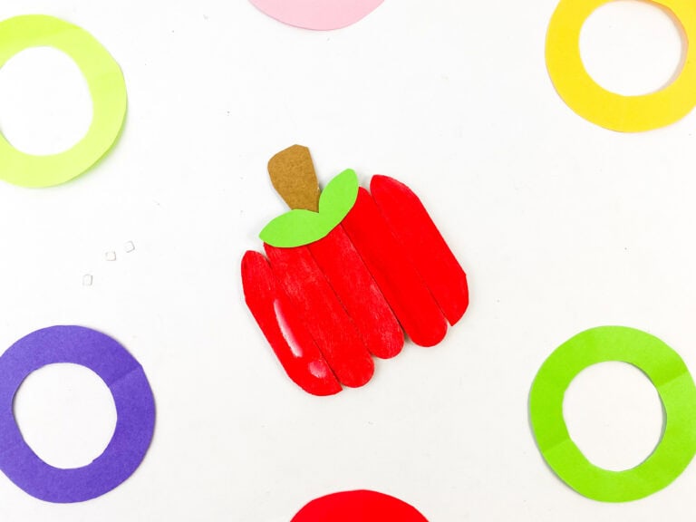 Red craft stick apple with brown stem and green leaves