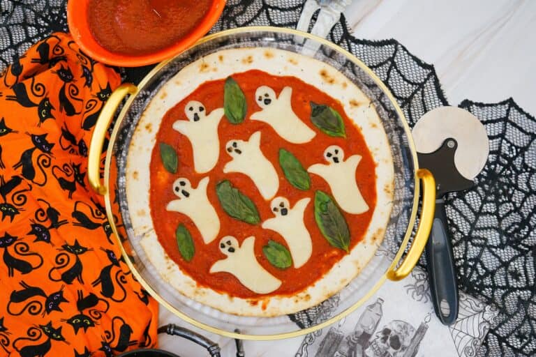 Up close shot of a ghost pizza with basil leaves