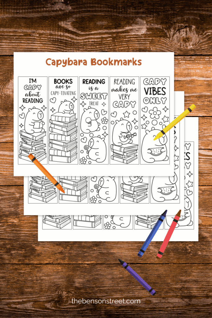 Wood table with sheets of capybara bookmarks on it with crayons ready to color them in