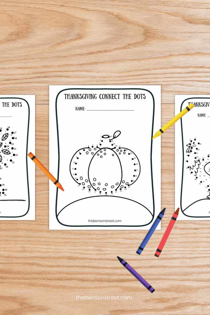 Three coloring pages for thanksgiving on a table with crayons scattered around