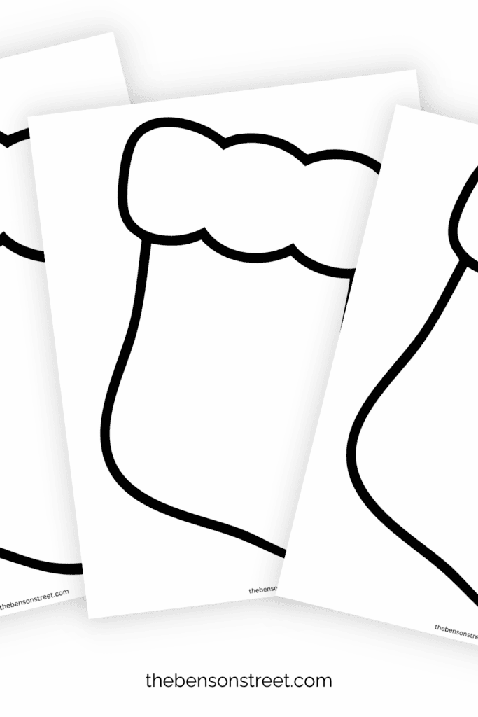 Three printed out sheets of blank stocking coloring pages in a fanned out stack