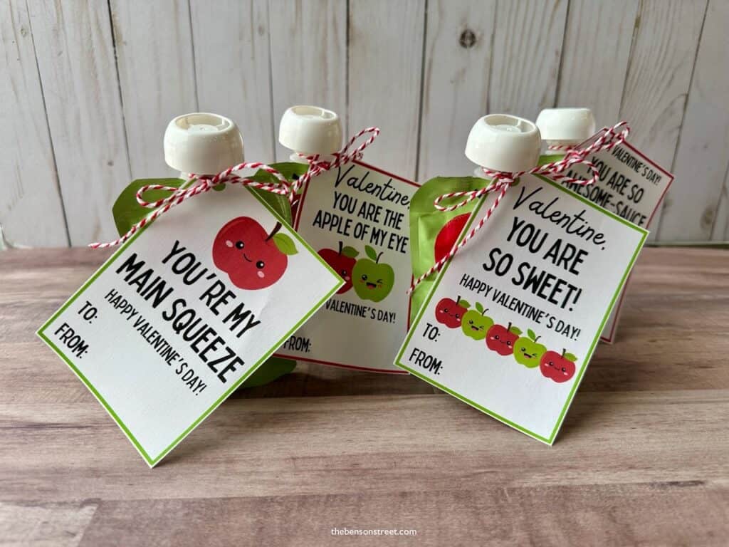Applesauce pouches with valentine tags and cute messages tied on with baker's twine
