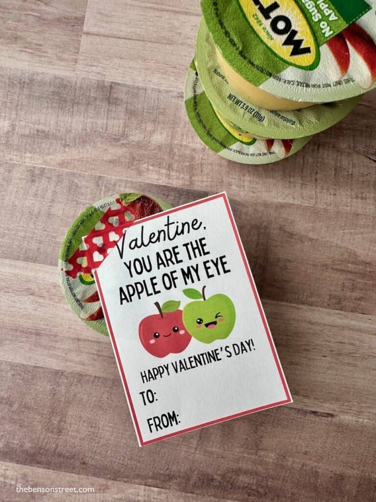 Overhead shot of a apple of my eye applesauce valentine tag on a applesauce cup