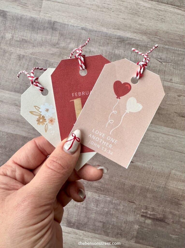 Hand holding three Scripture themed Valentine Tags