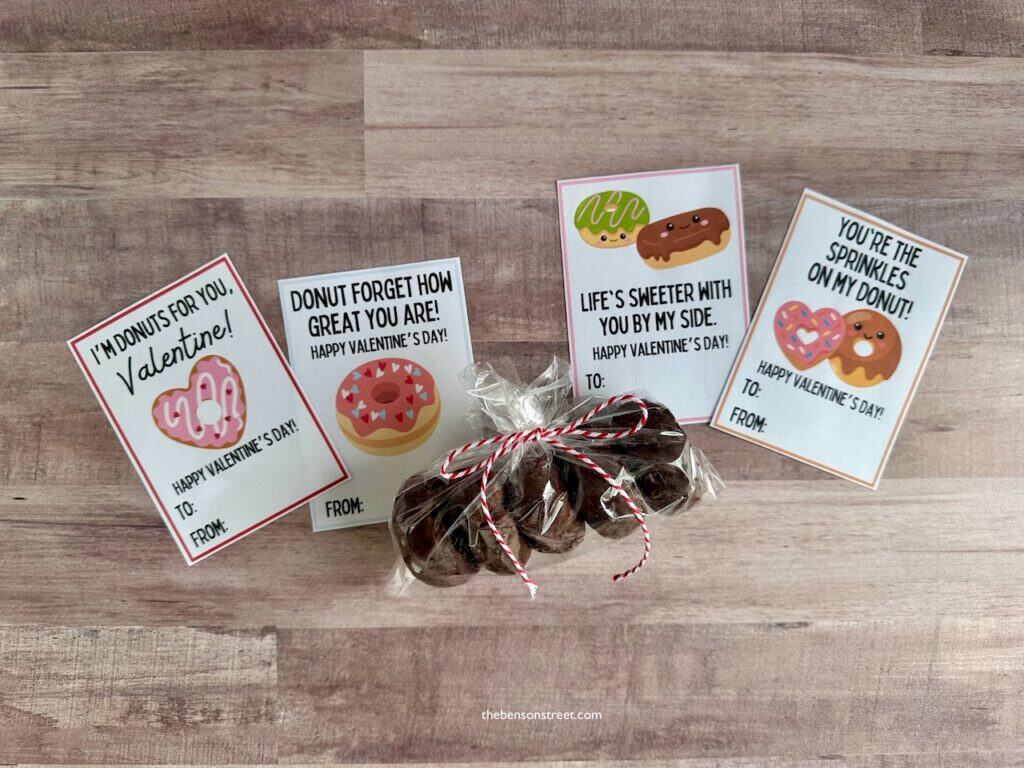 four donut themed free printable valentine cards with a bag of donuts