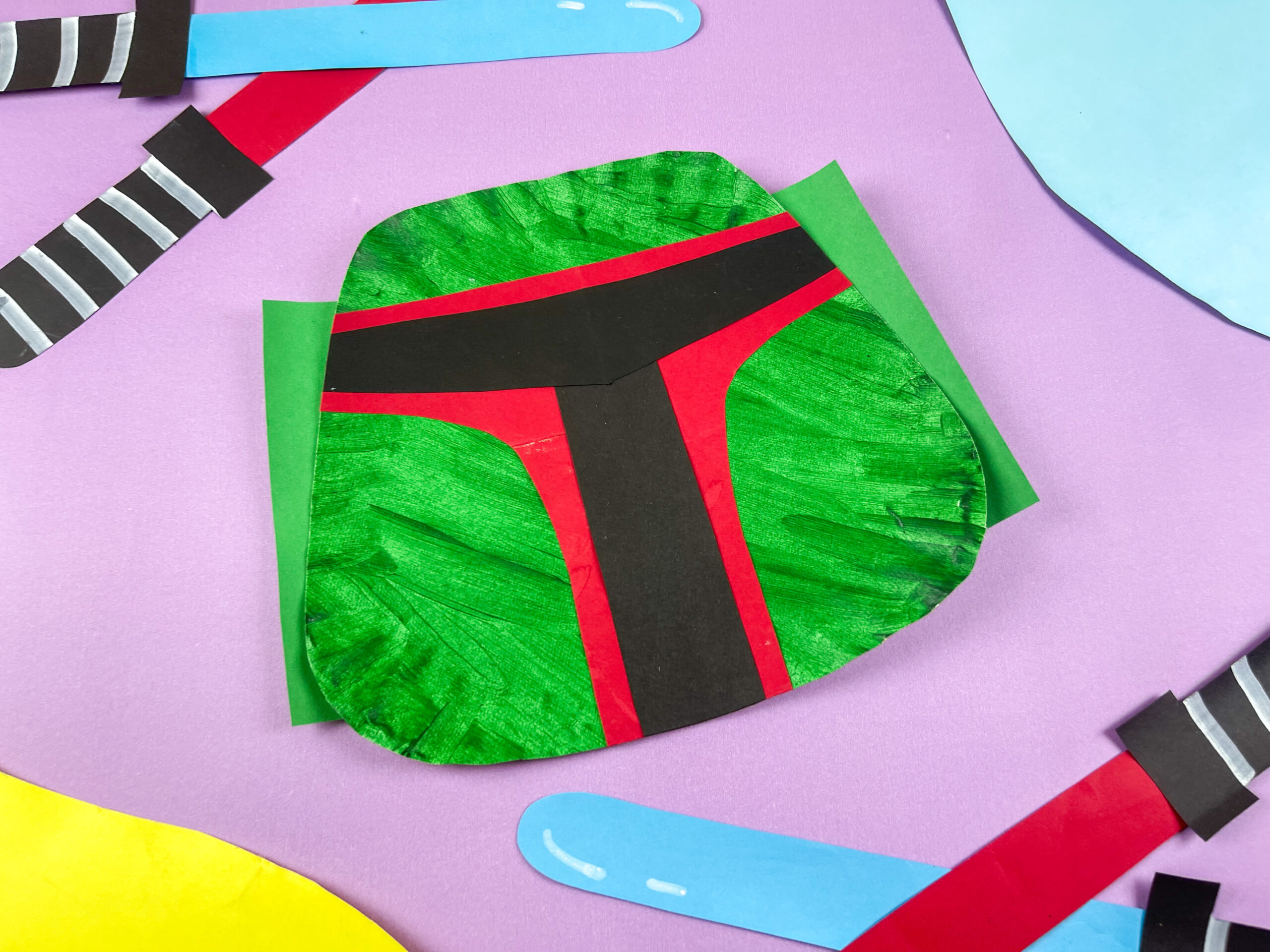 Green, red, and black paper craft for a boba fett mask