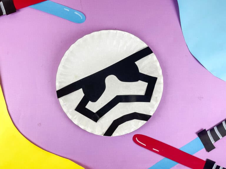 Paper plate stormtrooper with lightsabers in the background