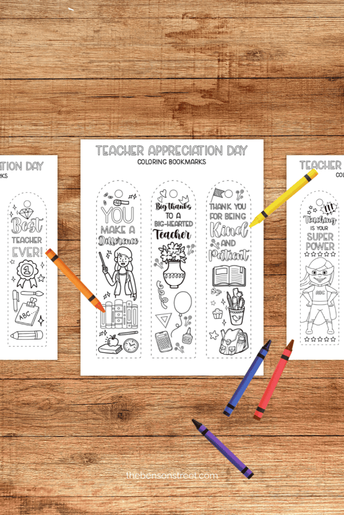 A wood table with coloring bookmarks for teacher gifts with crayons on top