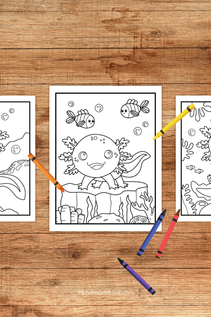 A table with coloring pages featuring axolotls and crayons laying around