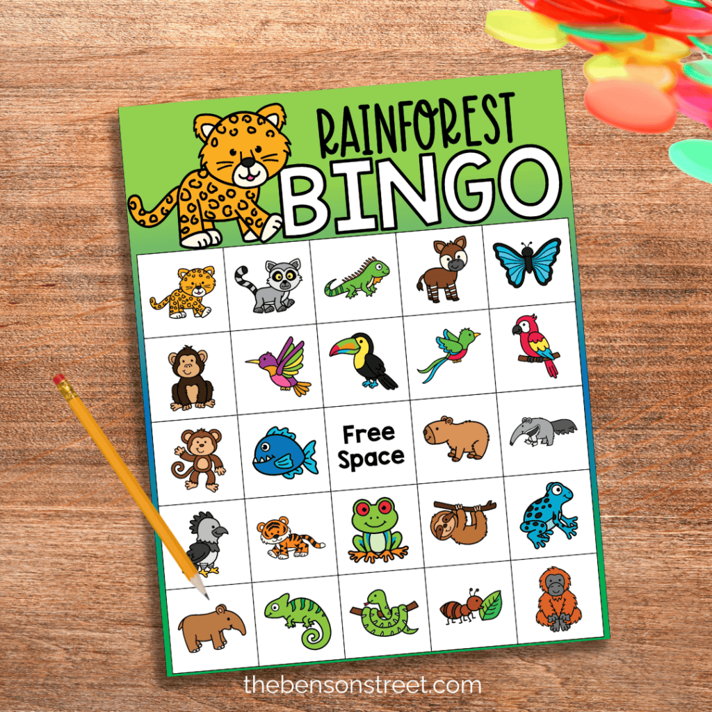 A page of rainforest bingo with animals on the squares with bingo chips and a pencil