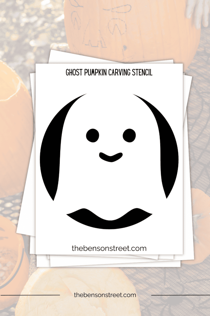Ghost Pumpkin carving template printable stencil on a stack of papers
