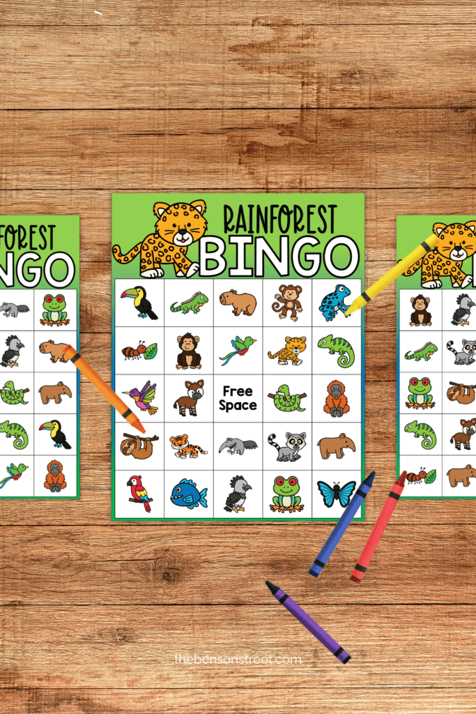 Three rainforest themed bingo boards with crayons on top