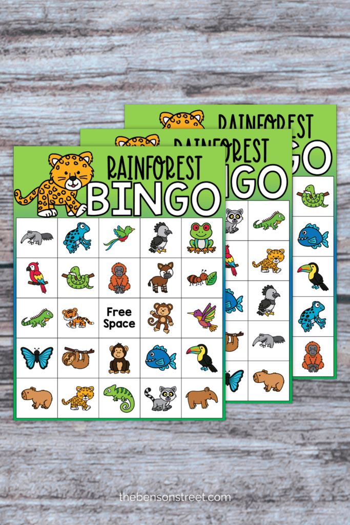 Three sheets of rainforest bingo on a wood background