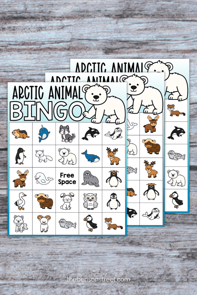 Three free bingo boards with arctic animals on them on a table