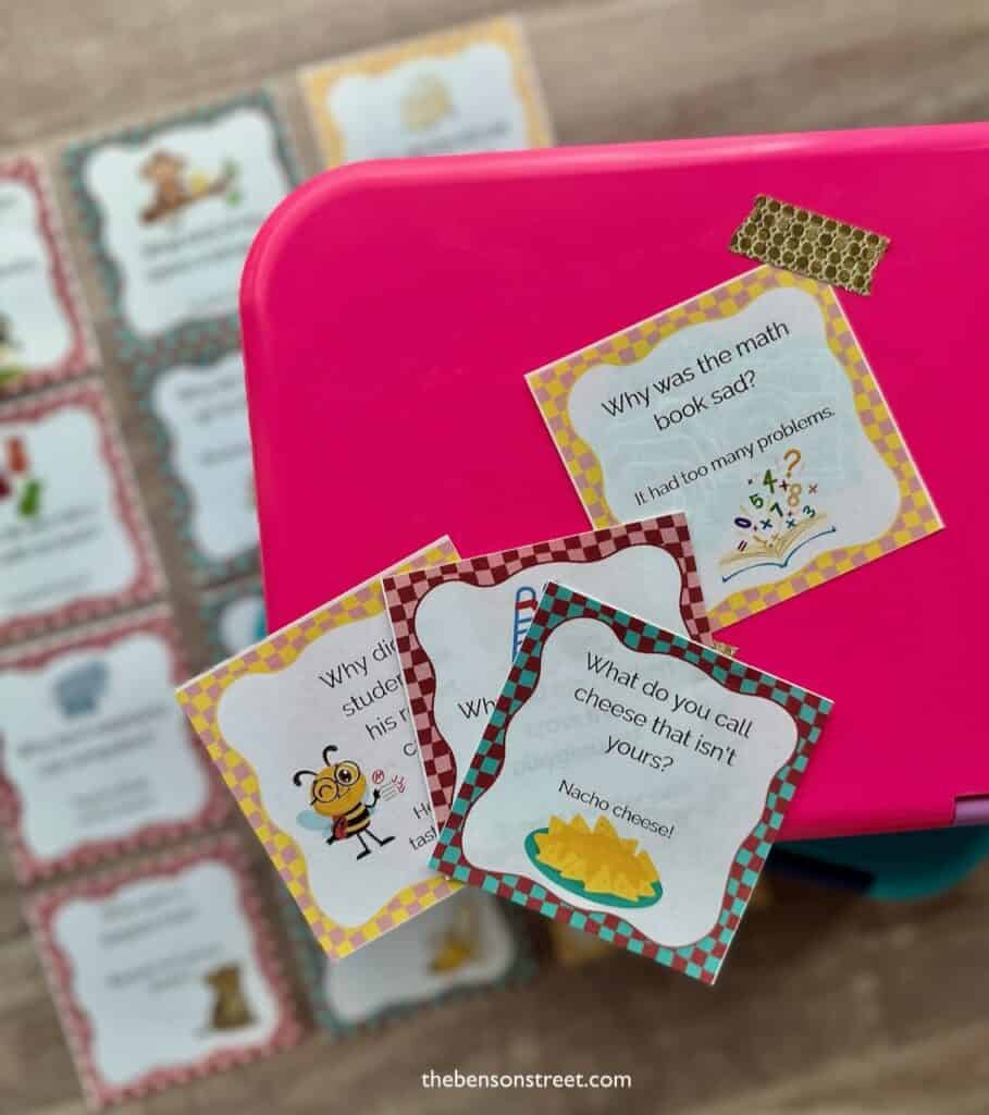 Bento box with a lunch box note taped to it and other underneath and laying on top