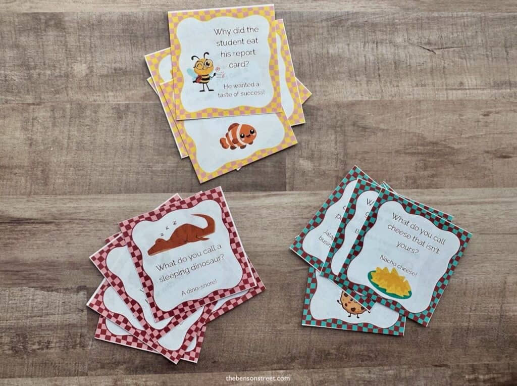 Stacks of jokes for kids lunches on a wood background