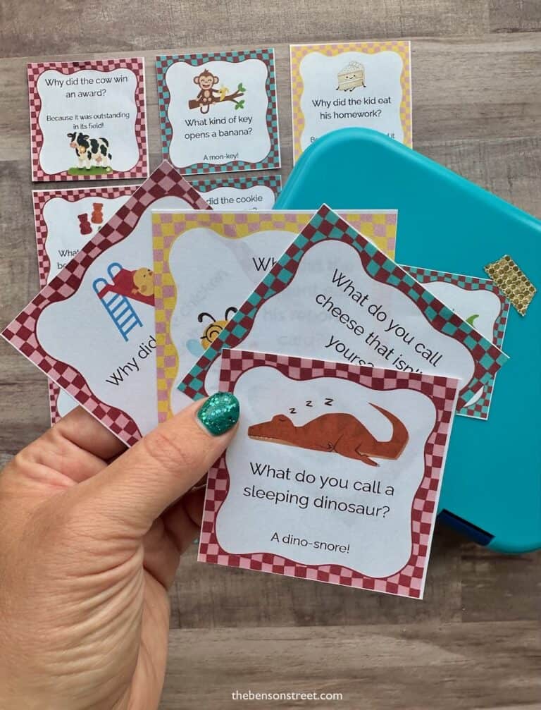hand holding lunch box notes with a bento box in the background